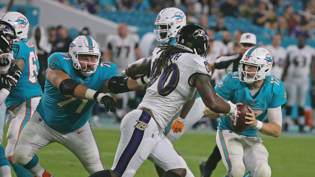 Miami Dolphins quarterback Ryan Tannehill scrambles for yardage as guard Josh Sitton tries to block Baltimore Ravens offensive linemen Za’Darius Smith in a preseason game. With Sitton and center Daniel Kilgore out for the season, the Dolphins offensive line is once again in an unenviable position.