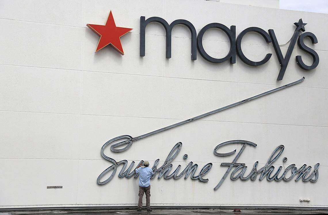 In this file photo from June 12, 2017, a repairman fixes the neon sign on the exterior of Miami Beach’s Macy’s that once was a Burdines store (hence the “Sunshine Fashions” lettering.)