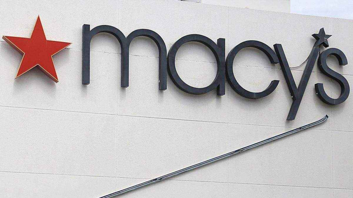 In this file photo from June 12, 2017, a repairman fixes the neon sign on the exterior of Miami Beach’s Macy’s that once was a Burdines store (hence the “Sunshine Fashions” lettering.)