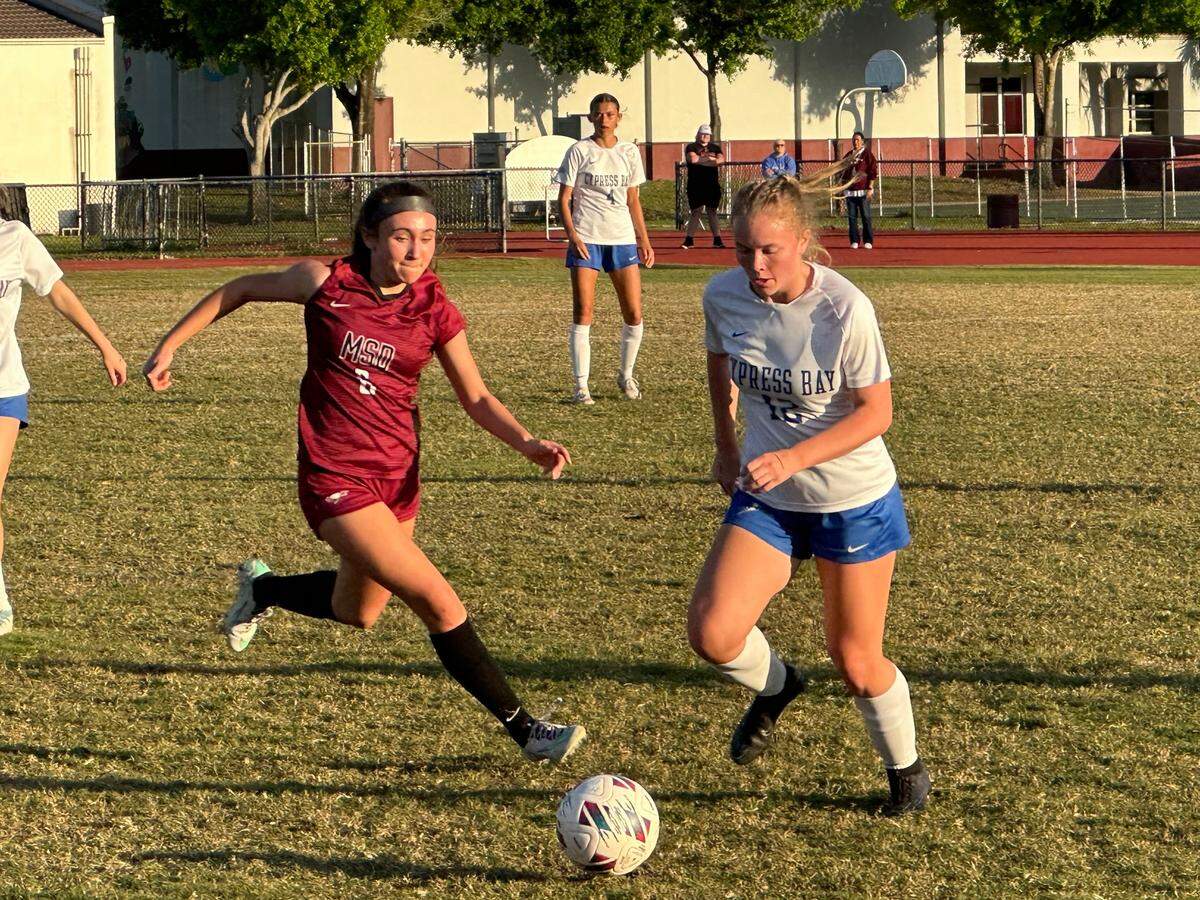 Stoneman Douglas’ Alexa Jourdan races to the ball before Cypress Bay’s Kiera Simmons during Wednesday night’s Region 4-7A girls’ soccer final at Douglas High.