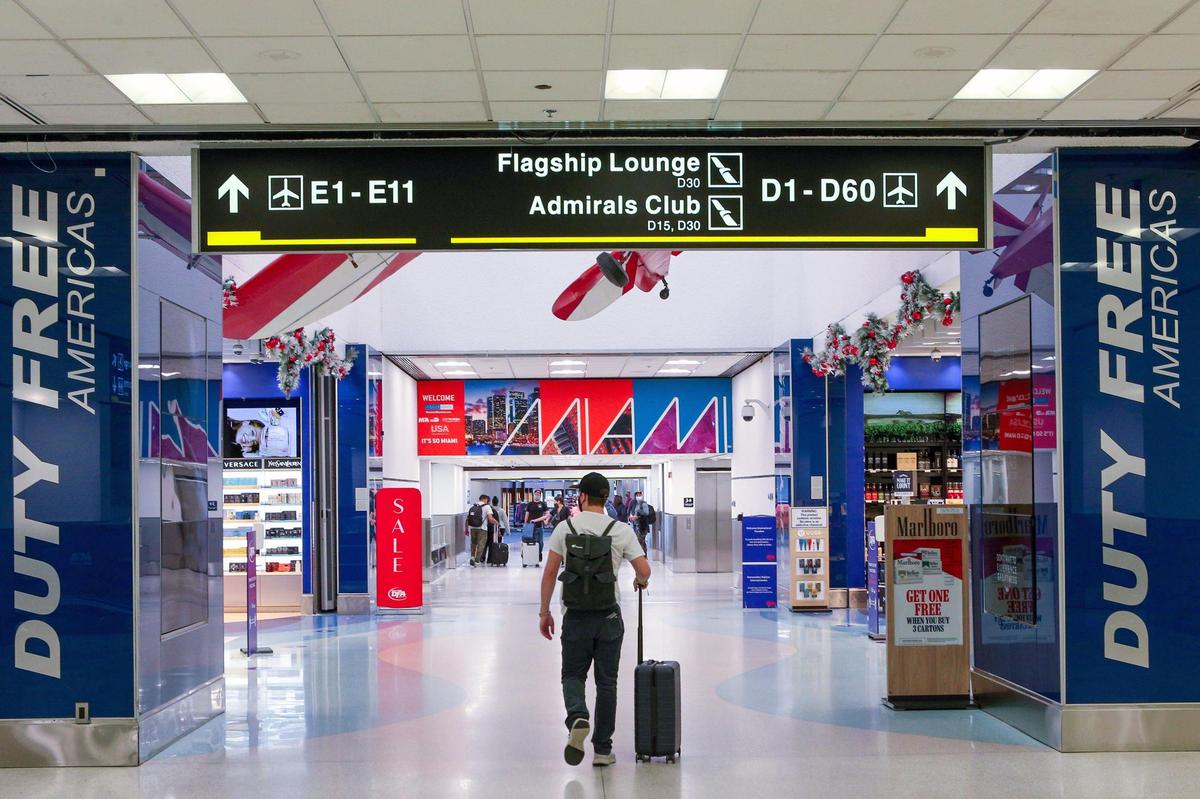 A traveler walks toward an open Duty Free shop at Miami International Airport in Miami, Florida, on Monday, Nov. 22, 2021.