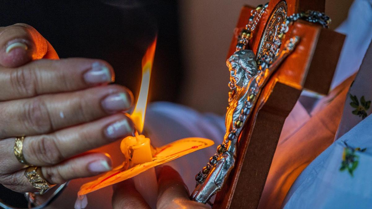 In this file photo, a woman holds a cross during a vigil held in Doral by the Venezuelan American Caucus in support of the extension of the TPS for Venezuelans.