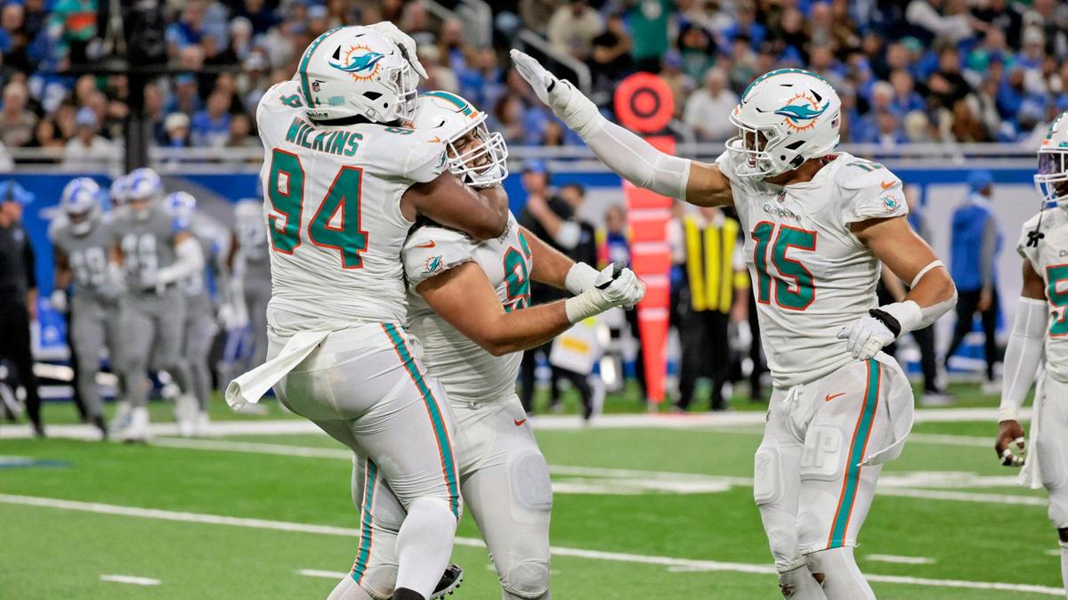 Miami Dolphins defensive tackle Zach Sieler (92) defensive tackle Christian Wilkins (94) and linebacker Jaelan Phillips (15) celebrate after Sieler sacks Detroit Lions quarterback Jared Goff (16) in the third quarter at Ford Field in Detroit, Michigan on Sunday, October 30, 2022.