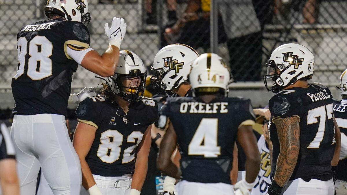 Central Florida tight end Alec Holler (82) celebrates his 23-yard touchdown reception with teammates, including tight end Jake Hescock (88), wide receiver Ryan O’Keefe (4) and offensive lineman Lokahi Pauole (77), during the first half of an NCAA college football game against Boise State on Thursday, Sept. 2, 2021, in Orlando, Fla.