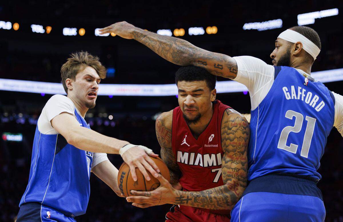 Dallas Mavericks forward Cooper Flagg (32) tries to take the ball from Miami Heat center Kel'el Ware (7) while guarded by Dallas Mavericks forward Daniel Gafford (21) during the first half of a game on Monday, Nov. 24, 2025, at the Kaseya Center in downtown Miami, Fla. 