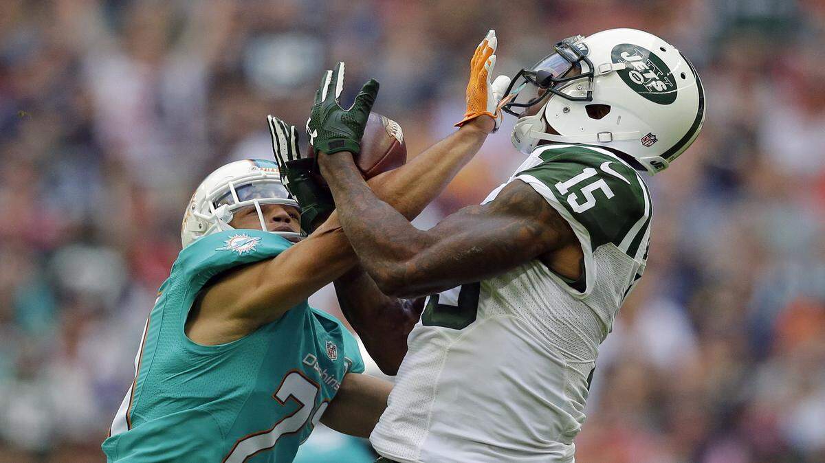 New York Jets' Brandon Marshall, right, catches the ball during the NFL football game between the New York Jets and the Miami Dolphins and at Wembley stadium in London, Sunday, Oct. 4, 2015.