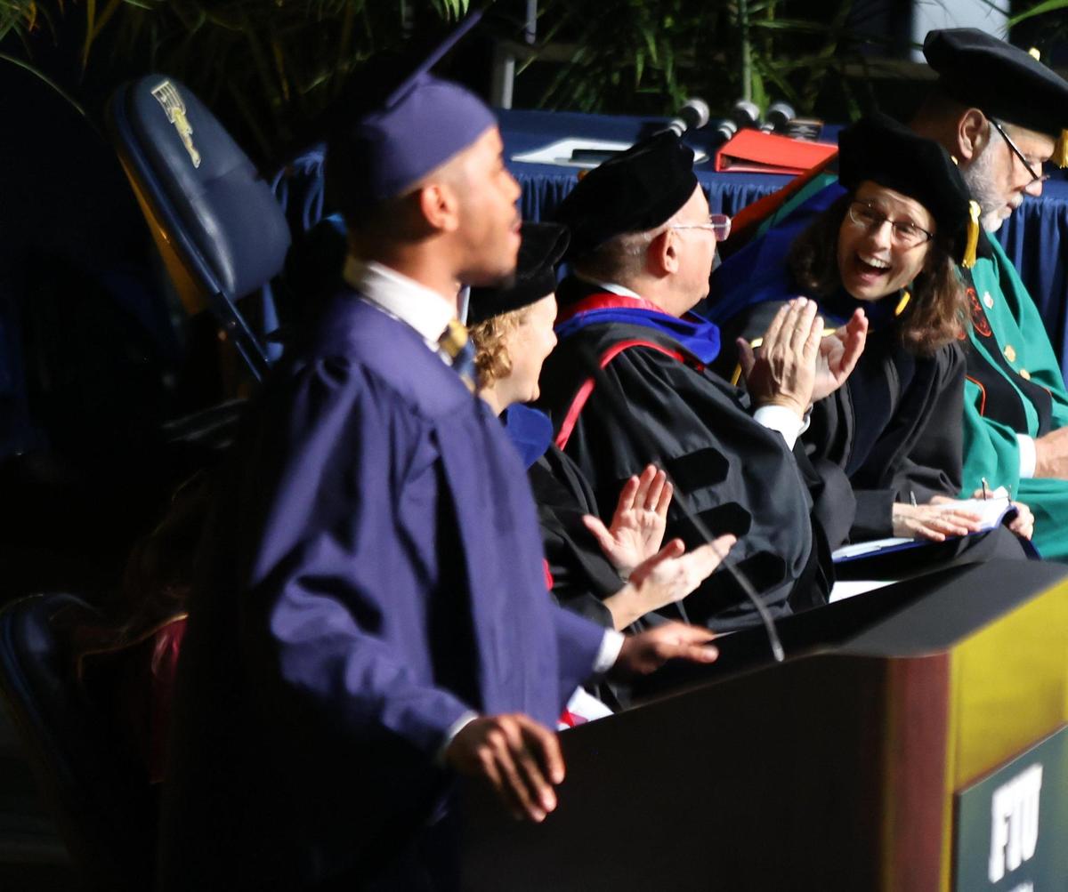 Lidia Kos, associate dean of the university’s graduate school, smiles widely as the Student Government President Cristhofer Lugo, delivers his speech during commencement.