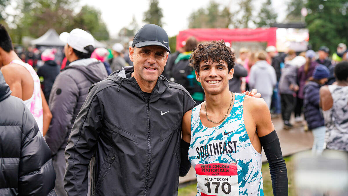 Belen Jesuit coach Frankie Ruiz (left) and junior runner Marcelo Mantecon (right) celebrate during the Wolverines’ Class 3A state championship win in November at the state cross-country championships in Tallahassee, Fla.