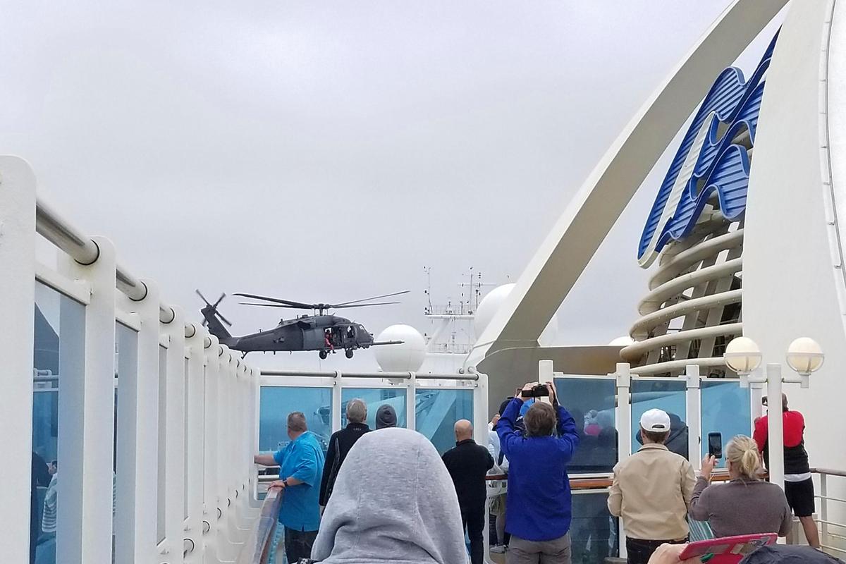 Passengers look on as a Coast Guard helicopter hovers above the Grand Princess cruise ship Thursday, March 5, 2020, off the California coast.