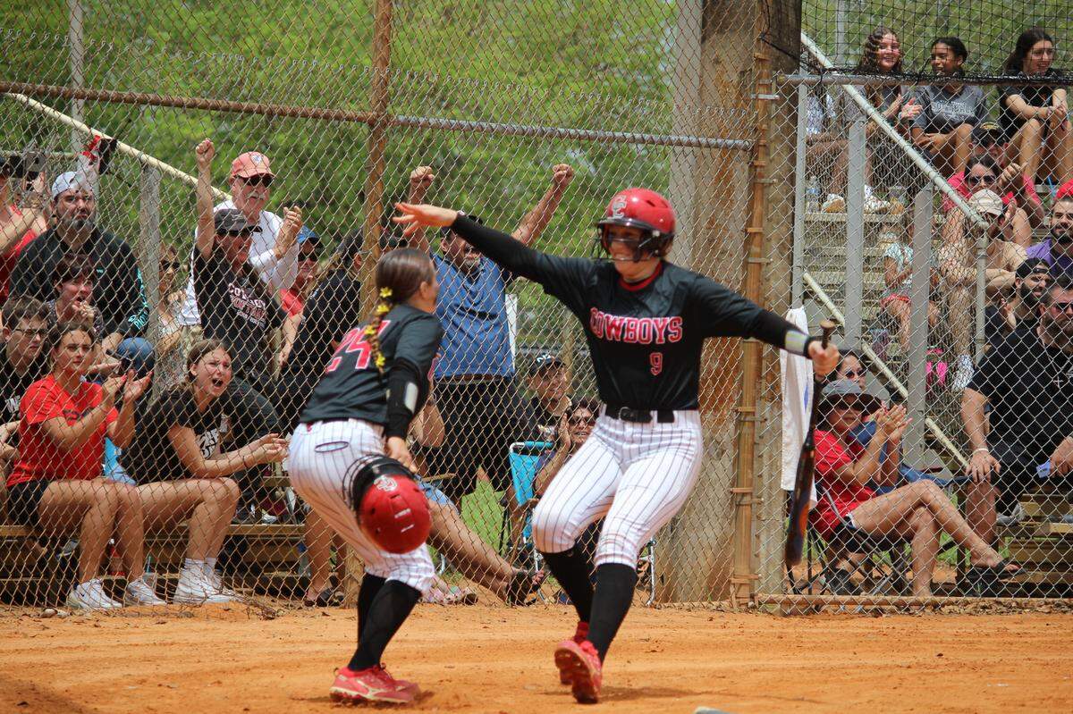 Sydney Totarsky (9) celebrates with Cooper City teammate Bianca Poustina after she scored a third inning run to put the Cowboys up 2-1 in the Region 4-6A final at Cooper City High.
