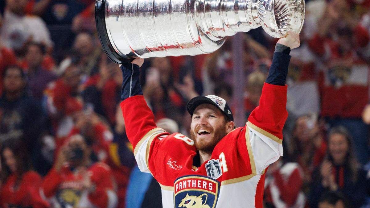 Florida Panthers left wing Matthew Tkachuk (19) lifts the Stably Cup after the Florida Panthers defeated the Edmonton Oilers in Game 6 winning the NHL Stanley Cup Final at Amerant Bank Arena