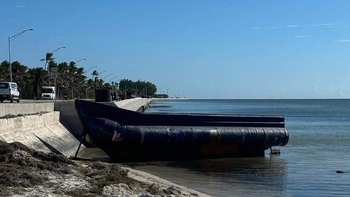 An abandoned migrant boat floats off a seawall at Higgs Beach in Key West Friday, Jan. 6, 2022. A migrant group arrived in a similar vessel the night before at Naval Air Station Key West’s Truman Annex, federal officials said.