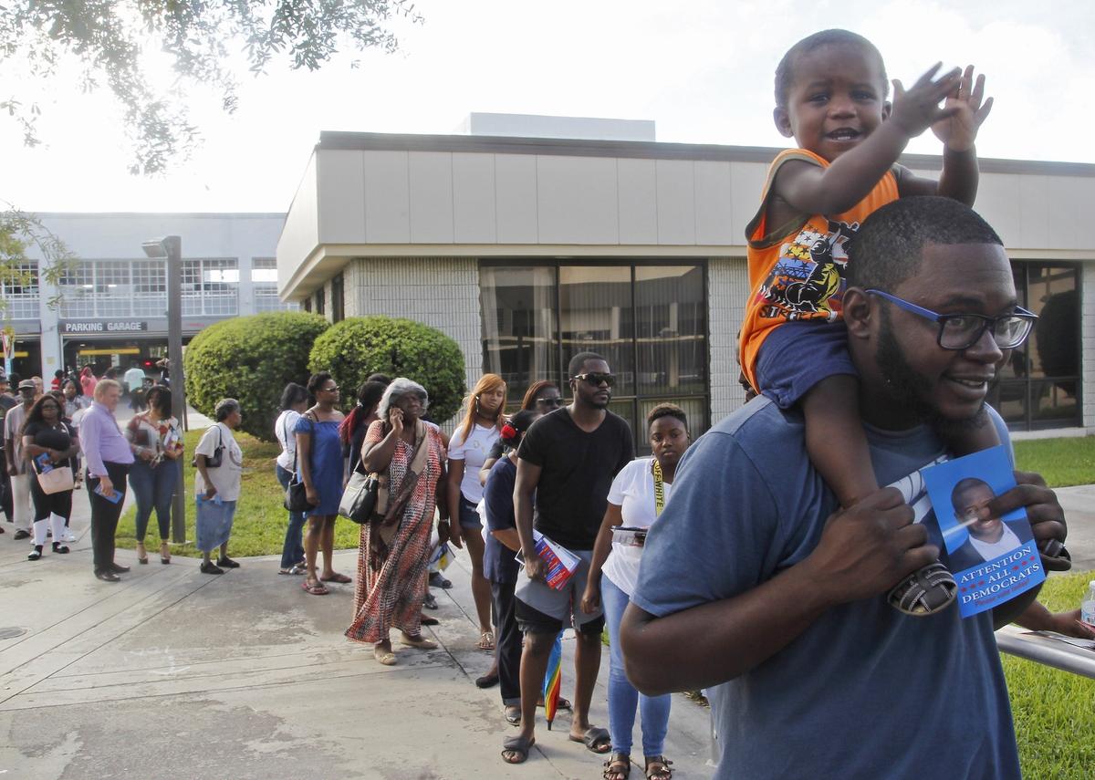 Voters line up outside an early-voting site at the Caleb Center in Miami on Sunday, Nov. 4, 2018.
