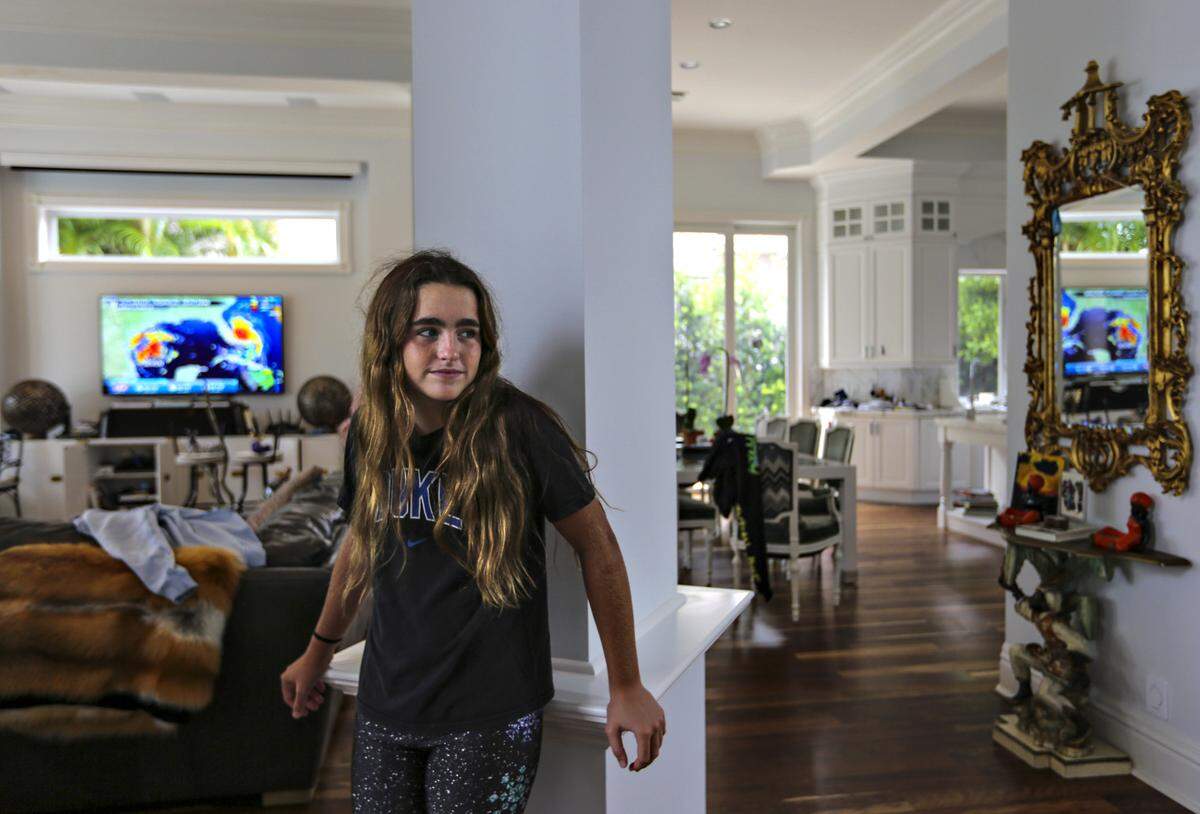 Claire Luce, 12, watches her mother as she works out inside while waiting for the latest news on the storm’s path as it moved slowly on a northern track about 100 miles off of Palm Beach, Florida on Tuesday, September 3, 2019.