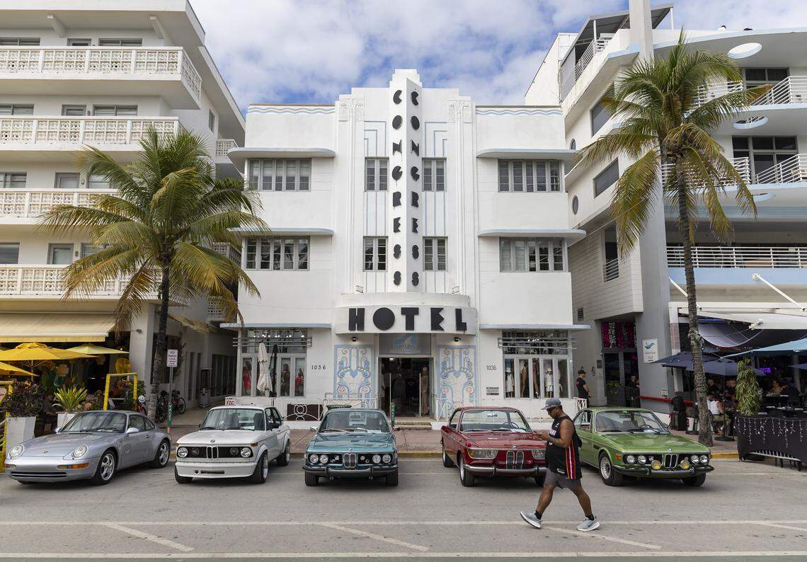 From left, various vintage cars in varying colors are parked in front of the white-colored Congress Hotel during Art Deco Weekend at Ocean Drive on Saturday, Jan. 10, 2026, in Miami Beach, Fla.