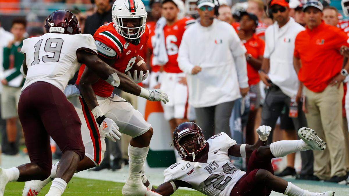 Miami tight end Brevin Jordan (9) is tackled by Bethune Cookman linebacker Marquis Hendrix (19) and cornerback Sam Marc (24) during the first half of an NCAA college football game, Saturday, Sept. 14, 2019, in Miami Gardens, Fla.