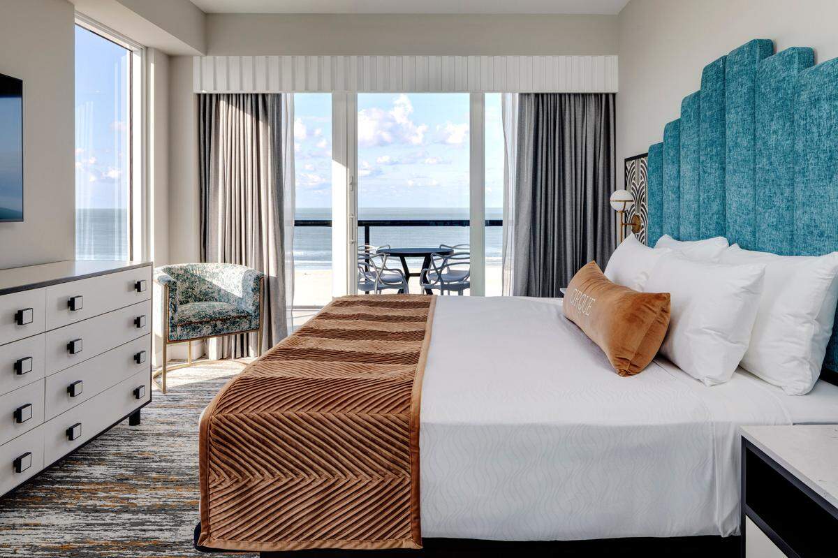 Spacious and serene, these apartment-style suites feature kitchen islands, wraparound couches, and balconies with beach views.