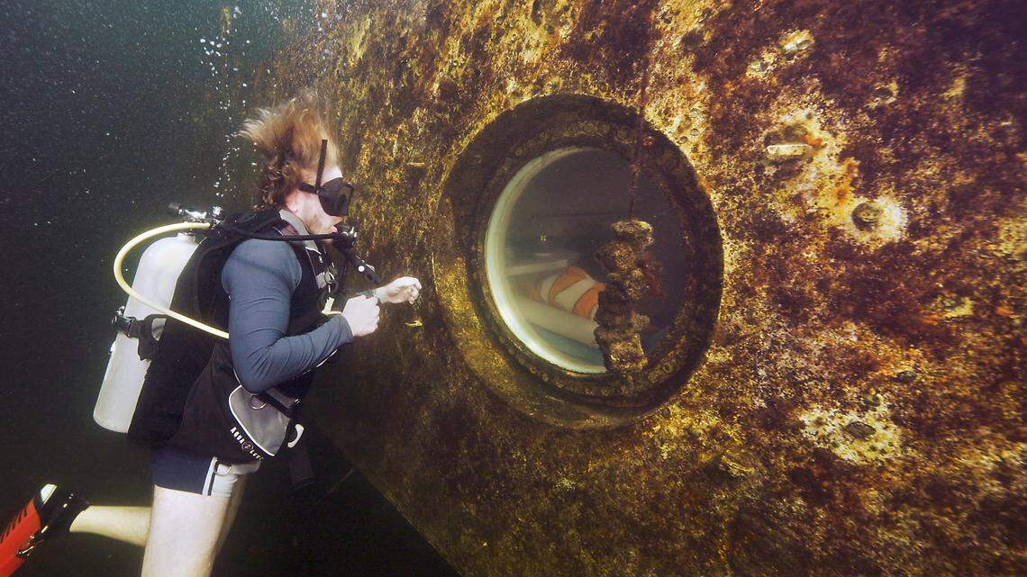Dr. Joseph Dituri peers through a porthole into the Jules’ Undersea Lodge habitat 30 feet below the surface in a lagoon Wednesday, March 1, 2023, in Key Largo. Dituri submerged to begin a planned 100 days in the habitat, establishing a new record for underwater human habitation at ambient pressure while conducting medical and marine science research.