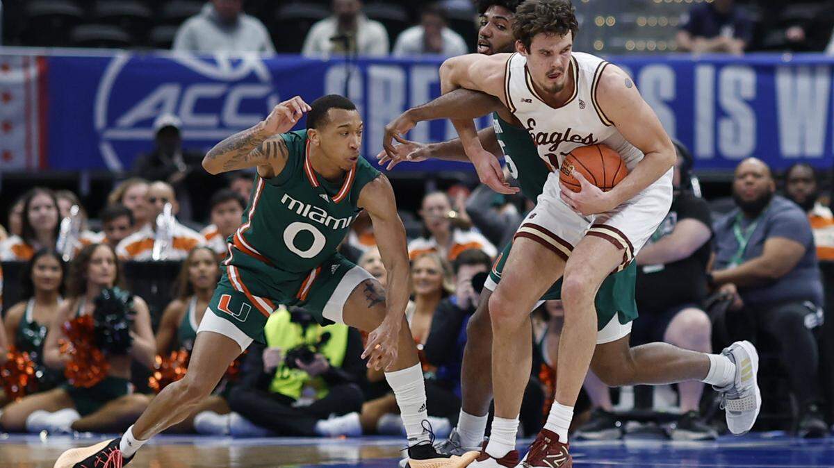 Mar 12, 2024; Washington, D.C., USA; Boston College Eagles forward Quinten Post (12) drives to the basket as Miami (Fl) Hurricanes guard Matthew Cleveland (0) and Hurricanes forward Norchad Omier (15) defend in the first half at Capital One Arena. Mandatory Credit: Geoff Burke-USA TODAY Sports
