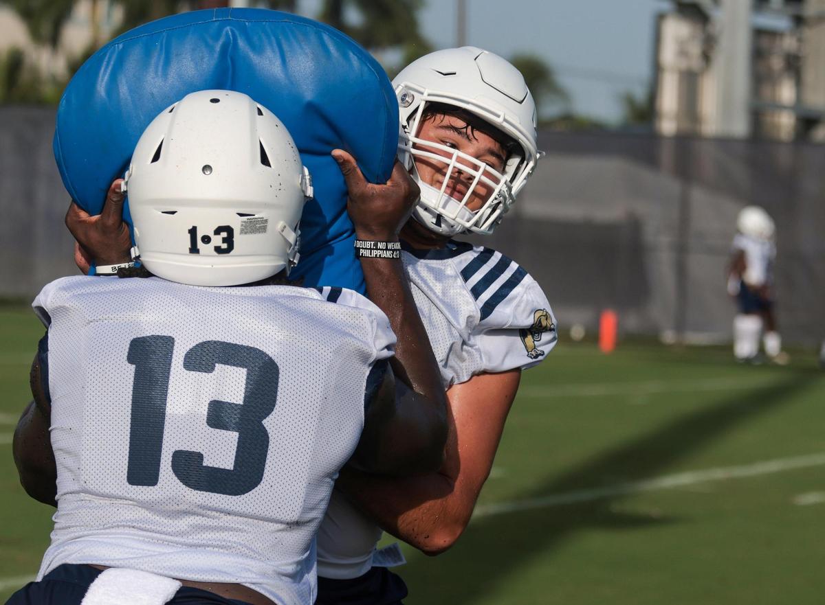 Offensive men Rivaldo Fairweather, #13, left, and tight end Brandon Ravelo, right, participate in line drills during practice. On Monday, August 1, 2022 FIU football team opened morning practiced to the media on the practice field on the Tamiami Campus.