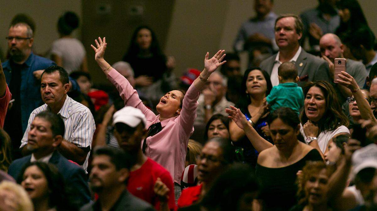 Attendees pray at the King Jesus International Ministry before President Donald Trump spoke at his Evangelicals for Trump rally in 2020. The church describes itself as a supernatural church where miracles happen.
