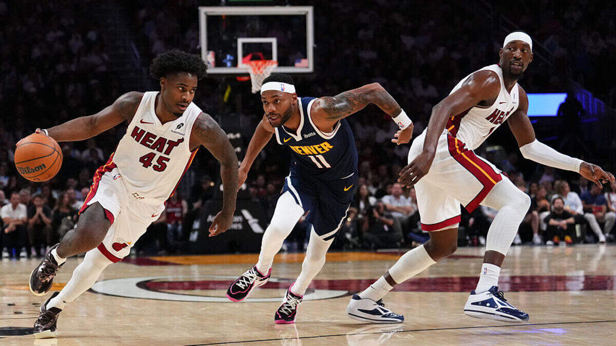 Davion Mitchell #45 of the Miami Heat dribbles the ball against Bruce Brown #11 of the Denver Nuggets during the second quarter at Kaseya Center on December 29, 2025 in Miami.