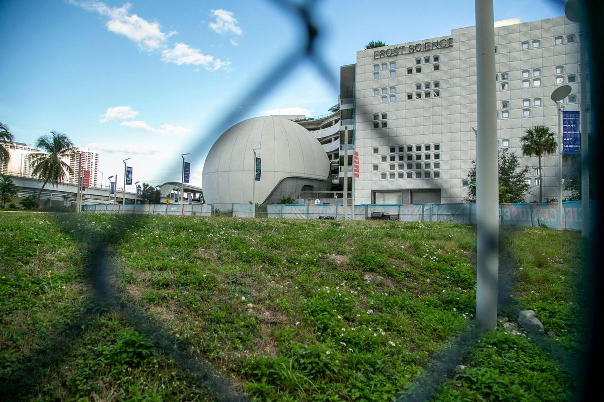A fenced vacant lot once used for construction staging sits on Biscayne Boulevard in front of the Frost Science Museum at the entrance to Maurice A. Ferré Park more than two years after all work was completed. Developer and philanthropist Jorge Pérez, who has given millions to the adjacent Pérez Art Museum Miami, calls the lot “shameful” and is offering to pay half the cost of beautifying it.