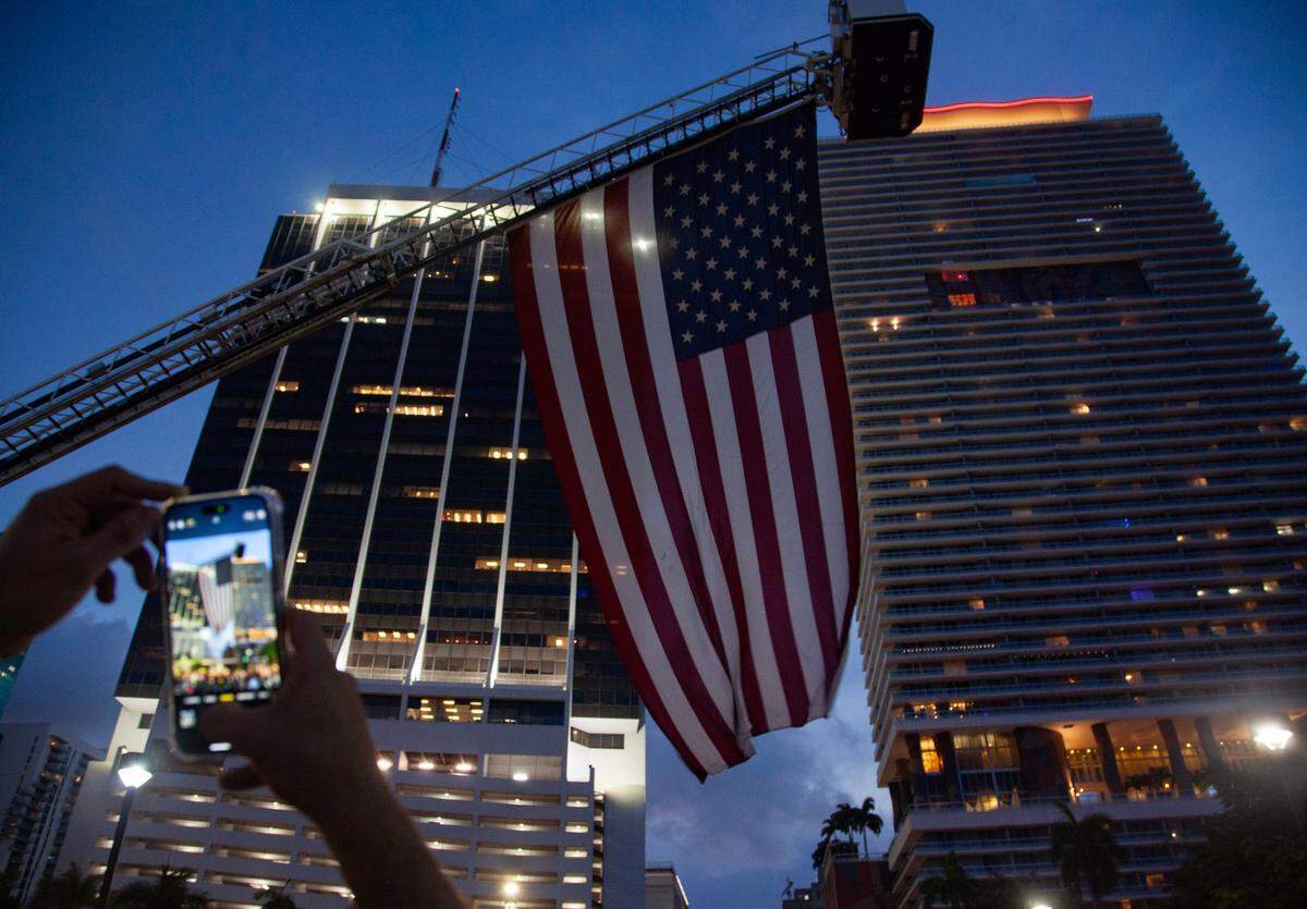 An attendee takes a photo of the American flag during the Fourth of July Bayfront Park Celebration at Bayfront Park on Tuesday, July 4, 2023 in Miami, Fla.