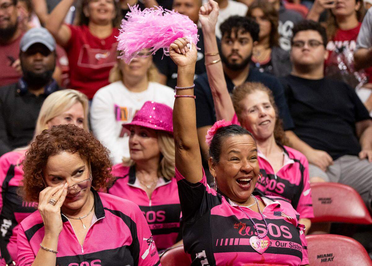 Vivian Campa, 59, a 4-year breast cancer survivor, waves a pink pompom while attending the Miami Heat’s Red, White & Pink intrasquad scrimmage game on Oct. 9, 2023, in Miami.