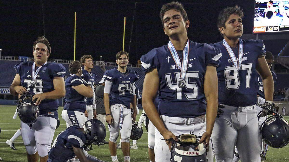 The Explorers Sabastian Porras (45) and Matthew De abreu (87) and fellow teammates react after Columbus is defeated by the Mandarin Mustangs during the Florida High School Athletic Association State Championship Class 8A at Camping World Stadium in Orlando on Saturday, December 8, 2018.