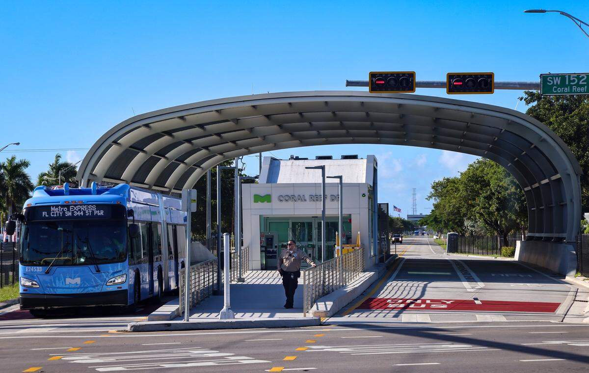 Express line bus stops for the frequent red light while as transit guard J. Sandfiel assures that bus commuters safely enters the station on the first day of Miami-Dade's $300 million rapid-transit bus line known as “Metro Express” on Monday, October 27, 2025, just west of Richmond Heights on Coral Reef Drive and U.S. 1. Many first day riders complained about crowded buses and long travel times due to red lights on the express lane.