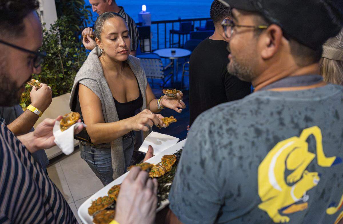 Sol Jativa serves herself Misty Points oysters from Cherrystone Aqua-Farms in Virginia during the Oyster Reefer by Everglades Oysters at The Standard on Thursday, Sept. 18, 2025, in Miami Beach, Fla. The event offered guests all-you-can-eat raw and cooked oysters for $80.