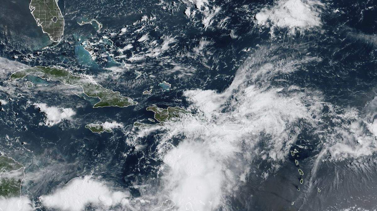 In this satellite image provided by the National Oceanic and Atmospheric Administration, Tropical Storm Franklin approaches Hispaniola on Tuesday. Authorities in the Dominican Republic prepared to shut down much of the country Tuesday as the storm took aim at the island it shares with Haiti.