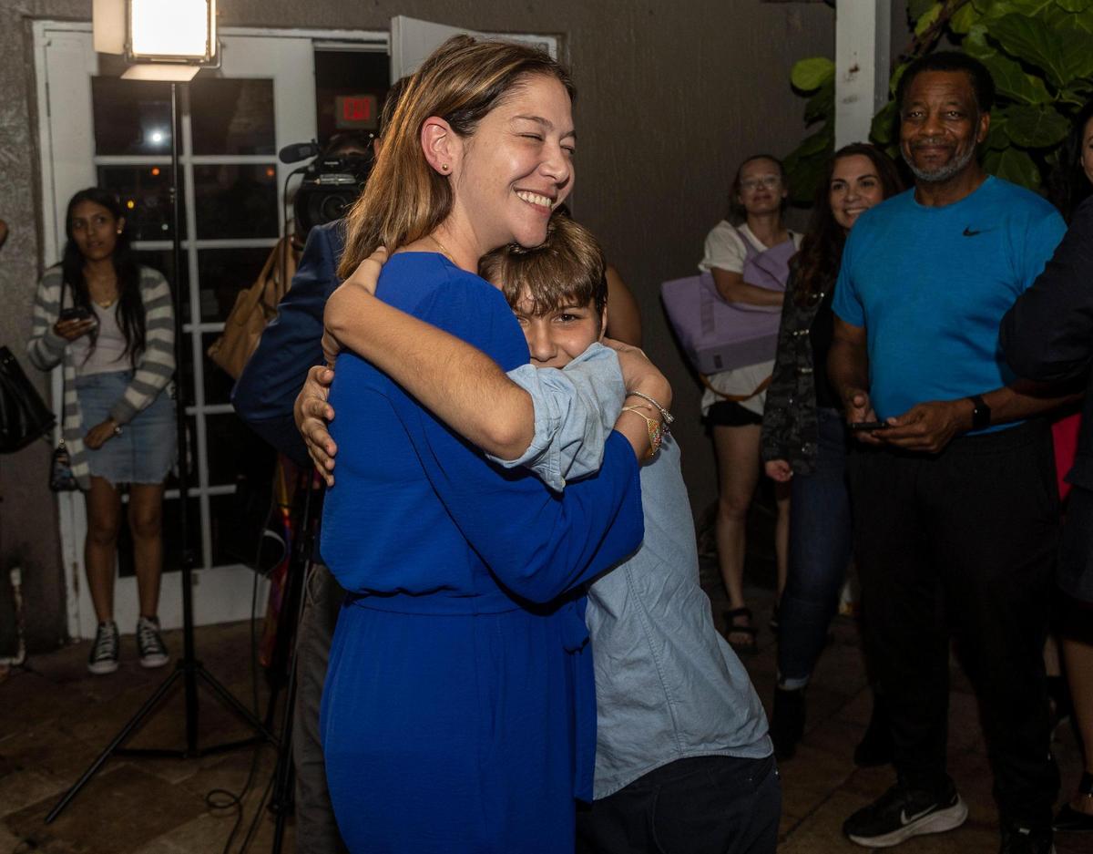 Sabina Covo, the winner of the District 2 special election in the city of Miami gets a hug from her 10-year-old son Paolo during a celebration at The Taurus in Coconut Grove, Feb. 27, 2023.