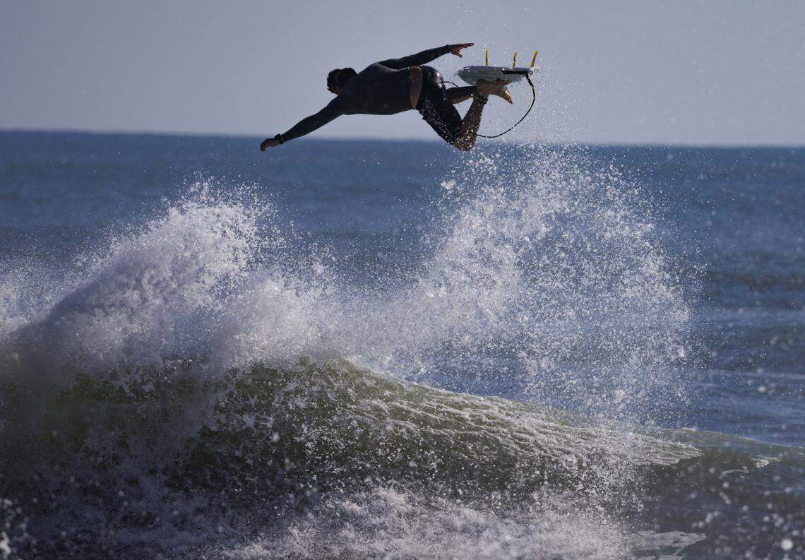 Joe Serrichio jumps off the top of a wave during the morning on Thursday, Aug. 21, 2025, off the beach in Stuart, Fla. Surfers estimated that waves ranged from 8 - 12 feet all morning.
