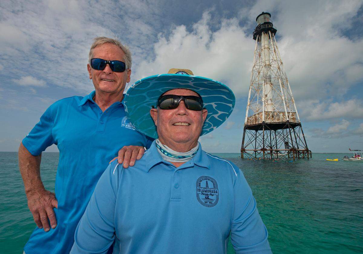 Rob Dixon, left, and Larry Herlth, right, pose near Alligator Reef Lighthouse Tuesday, Sept. 7, 2021, about four miles off of Islamorada, Fla., in the Florida Keys National Marine Sanctuary. Dixon and Herlth are part of the Islamorada-based nonprofit organization Friends of the Pool, Inc., who announced Tuesday that U.S. Secretary of Interior Deb Haaland approved a recommendation from the National Park Service that the organization be granted ownership of the lighthouse under the National Historic Lighthouse Preservation Act. Friends of the Pool hopes to raise about $9 million to preserve the almost 150-year-old structure.