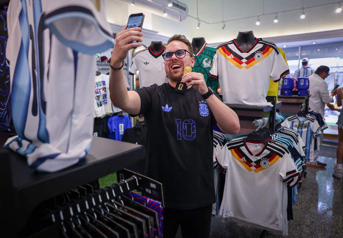 Niko Evans takes a video selfie with a miniature FIFA World Cup trophy.