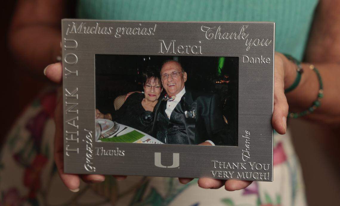 Daughter Lisa Palley holds a portrait of her parents Myrna and Sheldon Palley that was taken at a University of Miami Winter Wonderland gala hosted by the Frost School of Music.