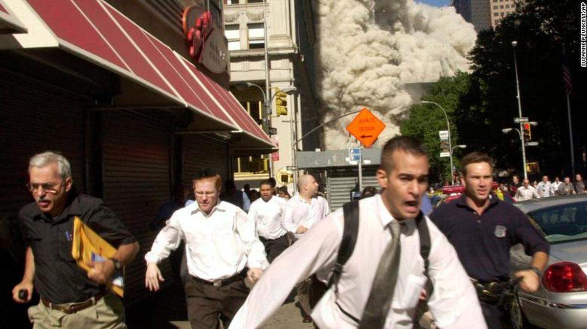Survivors run from the collapse of the World Trade Center Tower Tuesday, Sept. 11, 2001, in New York City. Stephen Cooper is at far left, wearing a black shirt.