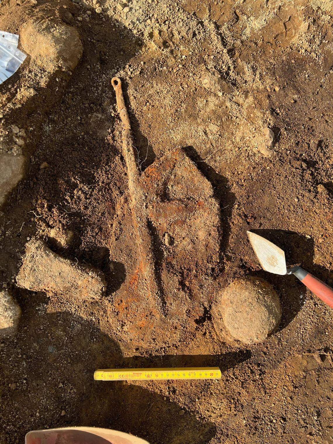 A mysterious artifact buried in the grave, possibly a frying pan.