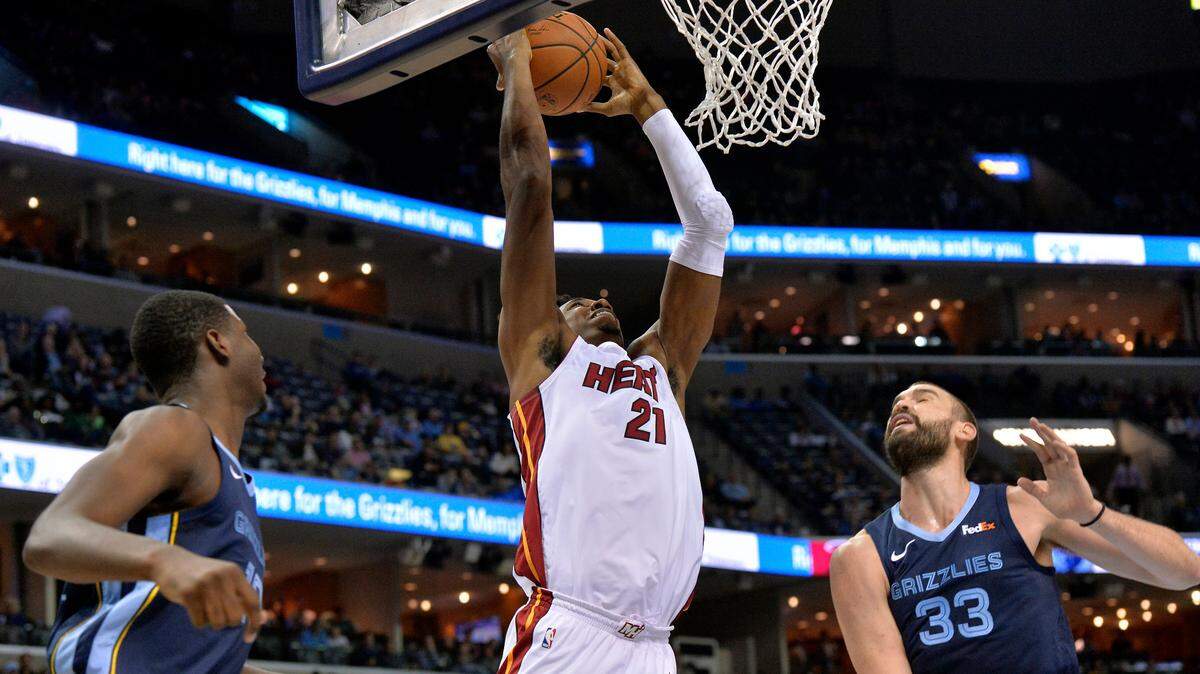 Miami Heat center Hassan Whiteside (21) jumps for a dunk between Memphis Grizzlies forward Jaren Jackson Jr., left, and center Marc Gasol (33) in the first half of an NBA basketball game on Friday, Dec. 14, 2018, in Memphis, Tenn.