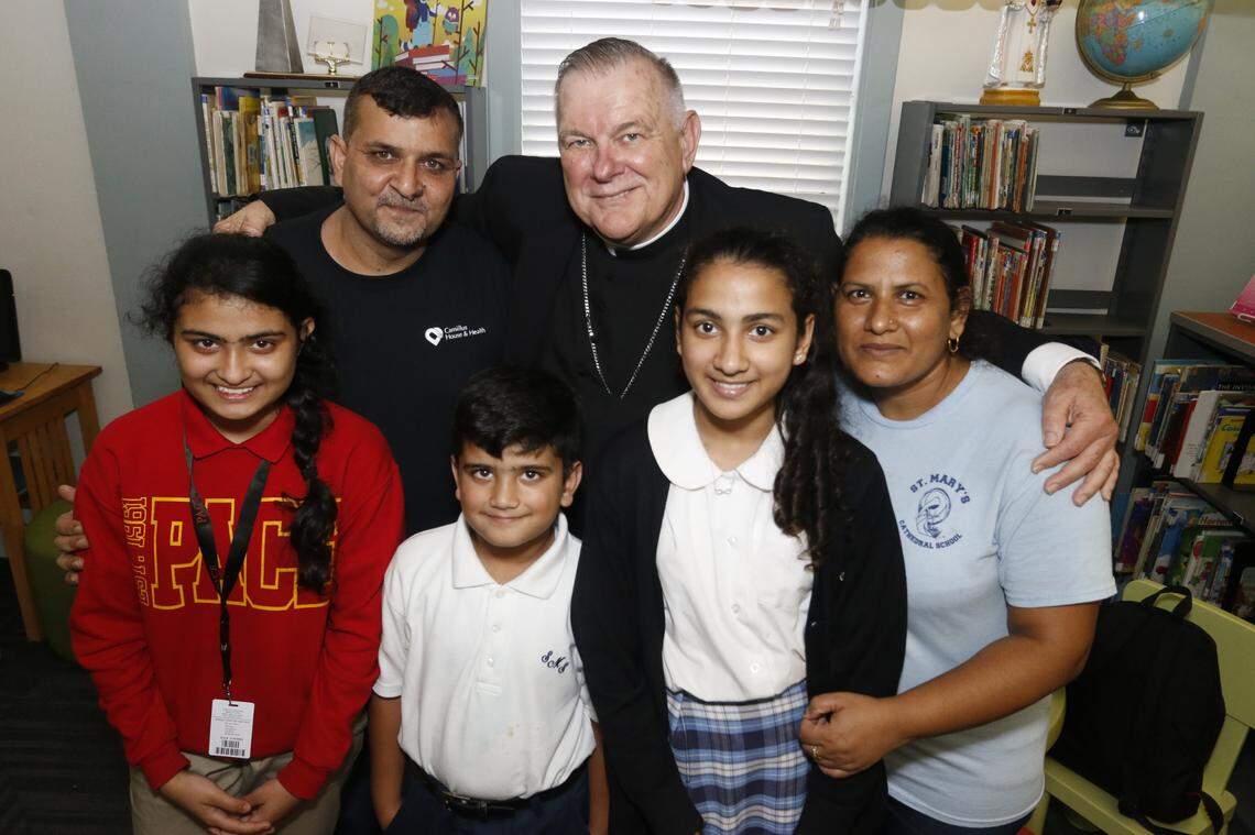 Miami Archbishop Thomas Wenski, pictured here with a Pakistani family admitted to the United States in 2016, is the target of anger from the administration of Florida Gov. Ron DeSantis, who is using the Department of Children and Families (DCF) to shut down unaccompanied minor immigrant children shelters like those run by the Catholic Church.