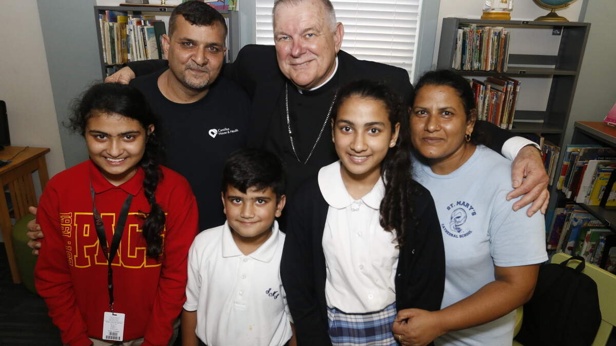 El arzobispo Thomas Wenski posa con la familia Tariq, católicos de Pakistán que ingresaron a Estados Unidos como refugiados en mayo de 2016.