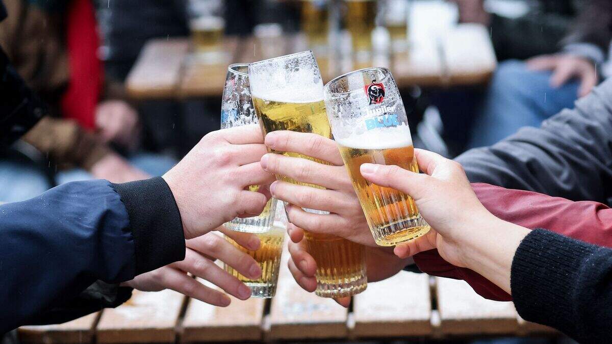 Friends toast each other as they drink a beer on a terrace in Brussels, on May 8, 2021, as the Belgium government eased the restrictions put in place to curb the spread of the coronavirus Covid-19.
