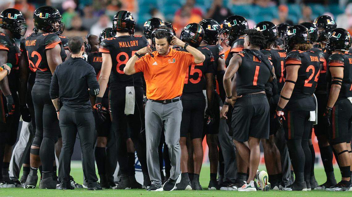 Miami Hurricanes head coach Manny Diaz on the field as the team huddles during a time out in the fourth against North Carolina State Wolfpack at Hard Rock Stadium in Miami Gardens on Saturday, October 23, 2021.