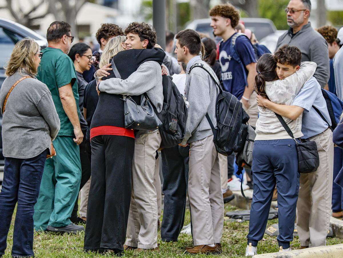 Students hug family members after being released from school after Miami-Dade Sheriff’s Office deputies responded to a threat made to Christopher Columbus High School on Southwest 87th Avenue on Wednesday, Feb. 4, 2026, in Miami. Authorities said the call was a false alarm that prompted a lockdown at the school, and everyone was safe.