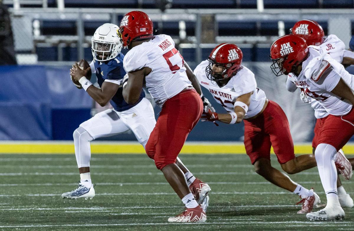 FIU Panthers quarterback Keyone Jenkins (1) runs with the ball as Jacksonville State defensive lineman Jeff Marks (57) goes for a tackle in the first half of their NCAA DI football game at the FIU Football Stadium on Wednesday, Oct. 25, 2023, in Miami, Fla.