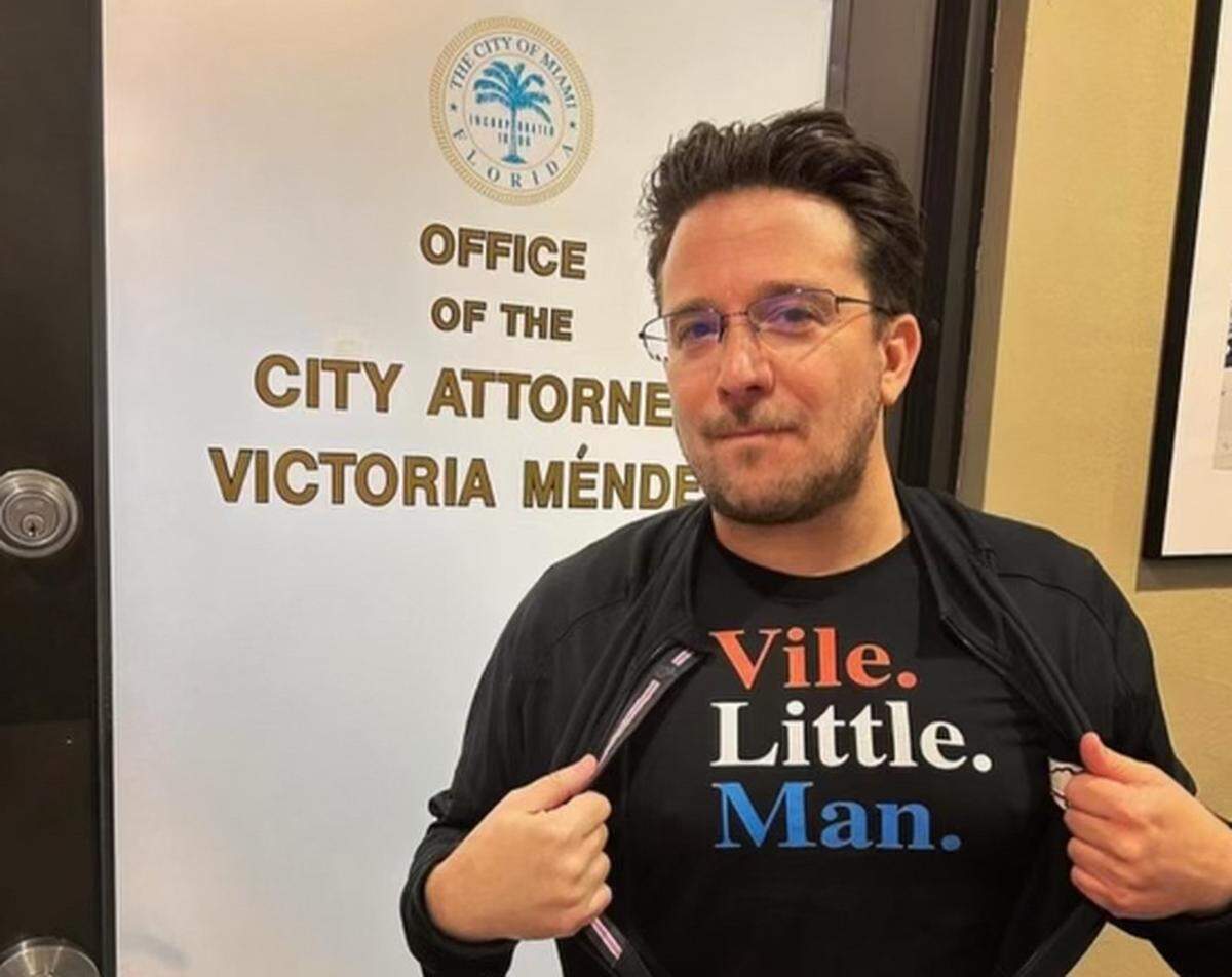 Filmmaker Billy Corben in Miami City Hall wearing a t-shirt inspired by then-City Attorney Victoria Méndez’s public remarks calling him a “vile little man.”