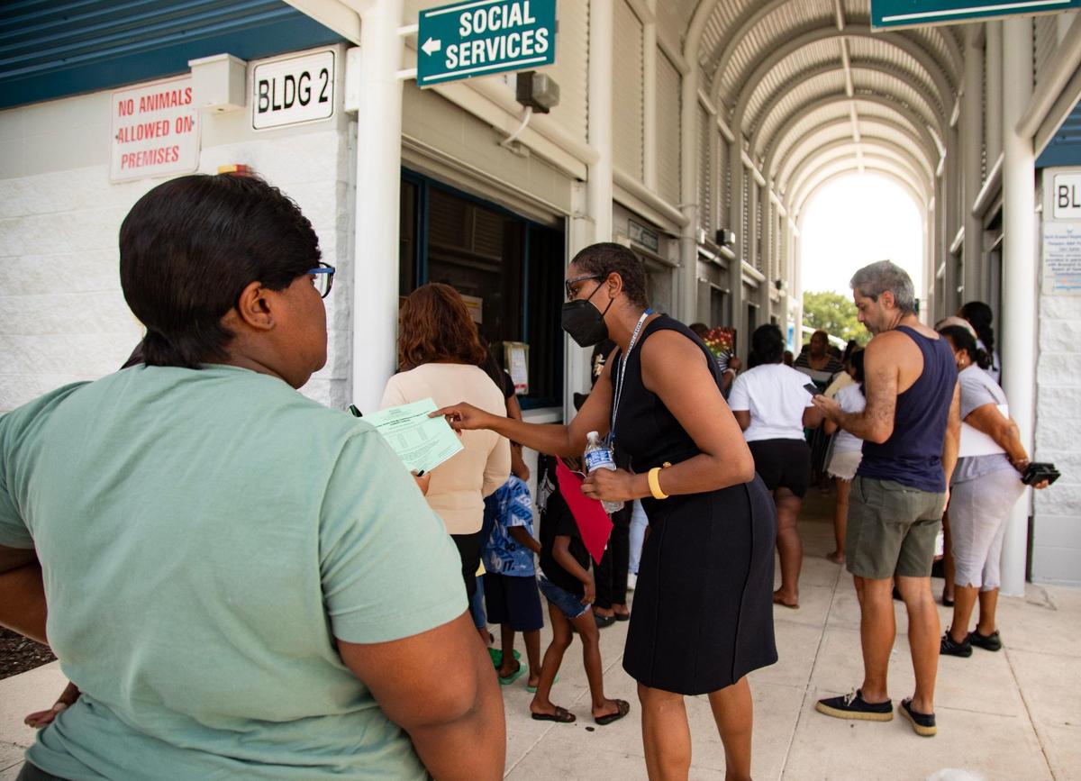 Natalie Moffitt, directora de la Administración del Éxito Familiar del Condado Broward, habla con una persona que espera para inscribirse en LIHEAP, un programa de asistencia para facturas de electricidad, en el Annie L. Weaver Health Center, en Pompano Beach, Florida, el jueves 20 de julio de 2023.