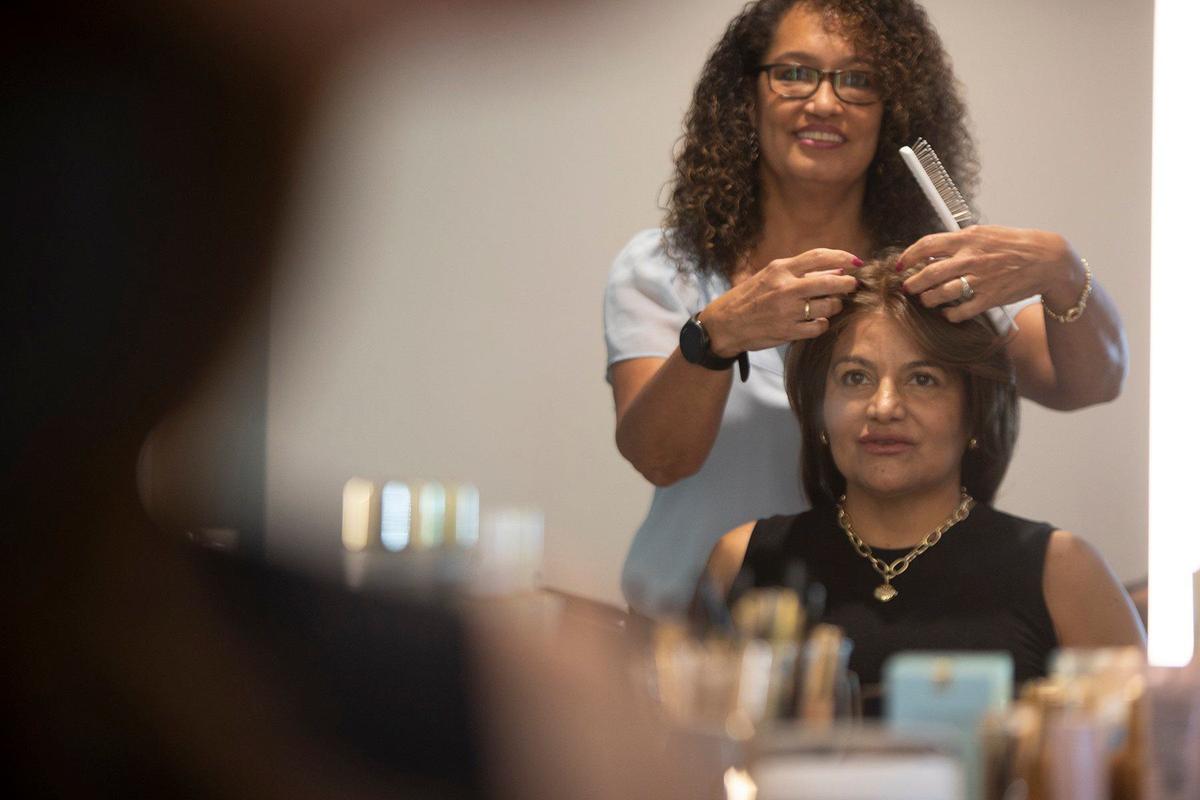 (Back) Sofie Stachl-Arroyo, assistant at Memorial Cancer Institute’s Center for Body, Mind & Spirit helps Diana Fontalvo to put a wig during the center’s grand opening in Pembroke Pines on Wednesday, May 29, 2024. The center offers a variety of spa and salon services to cancer patients including personalized wig fittings, head coverings, lymphedema services and skincare products.